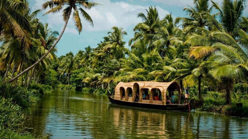 Suitcase with clothes, passport, camera, sunscreen, and travel accessories placed beside Kerala's beautiful backwaters.